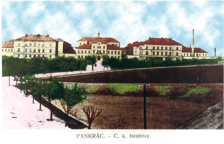 Historický pohled na věznici v Pankráci s budovami a okolní zeleň.
