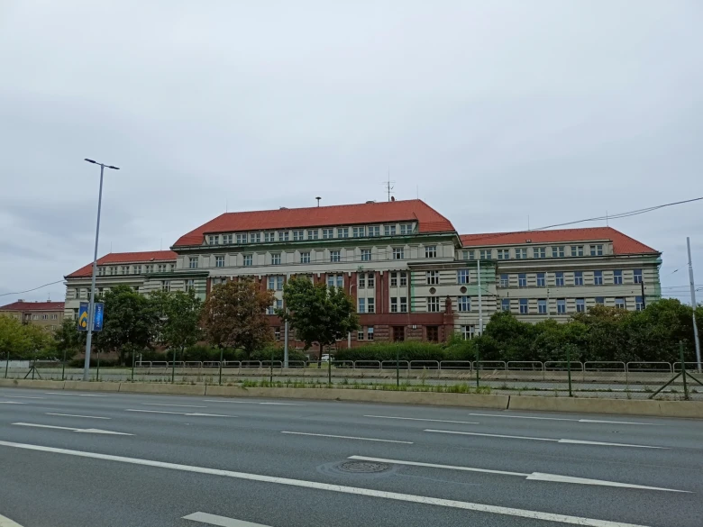 Věznice na Pankráci s červenou střechou viditelná z ulice.