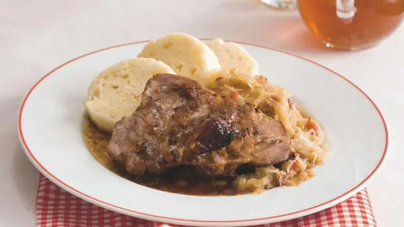 Svíčková s kysaným zelím a knedlíkem na talíři.
