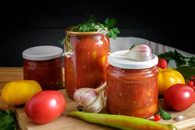 Sklenice zeleninového leča s čerstvými rajčaty, cibulkou a paprikami.