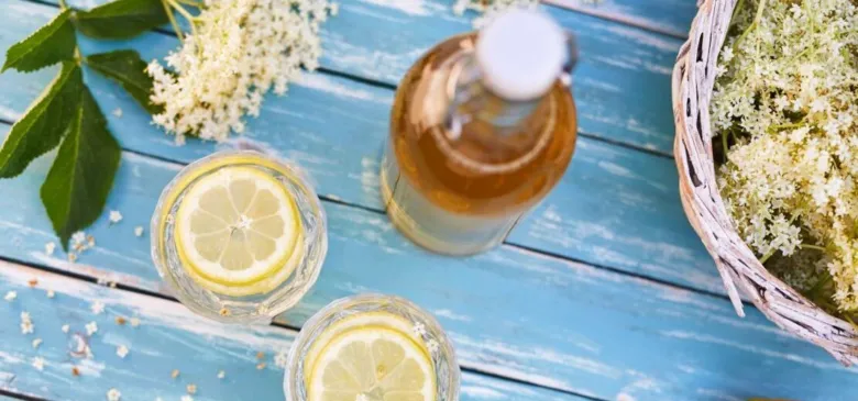 Příprava bezinkové limonády s čerstvými květy a citronem.