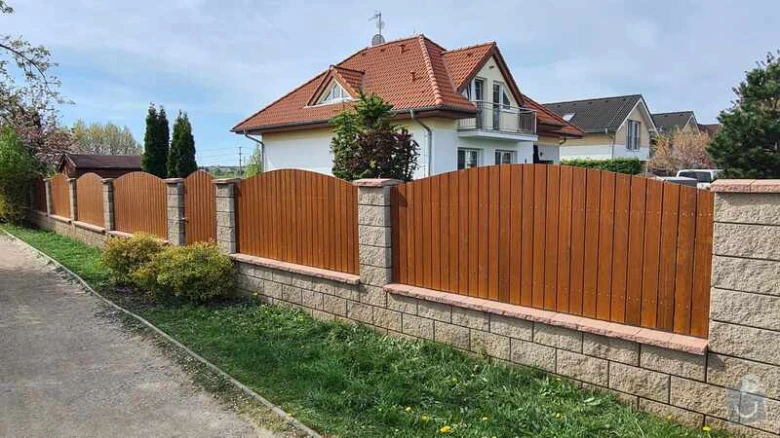 Moderní dřevěný plot s kamenným základem u rodinného domu.
