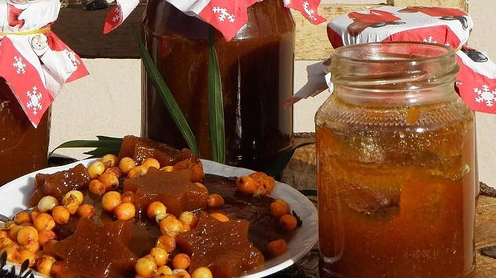 Příprava rakytníkové marmelády s čerstvými plody v sklenicích.
