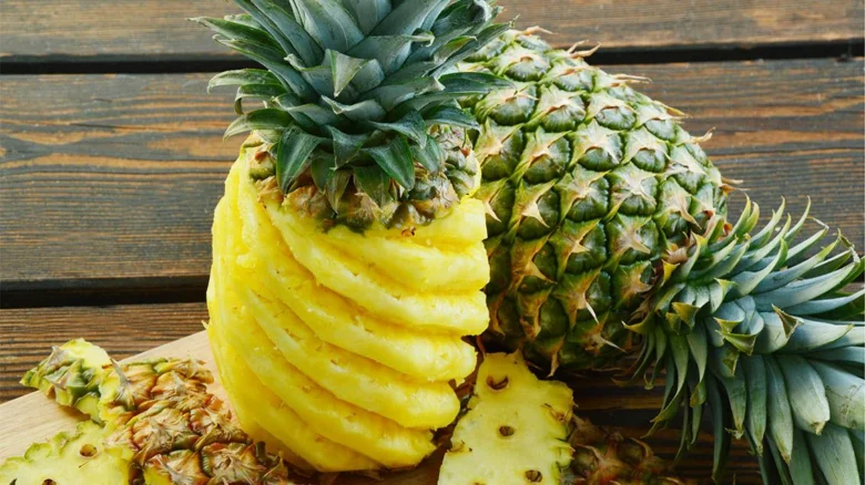 Ananas svinutý šroubovicí metodou na dřevěném povrchu.