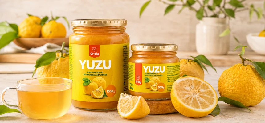 Celé i nakrájené ovoce yuzu s džemem v sklenicích.