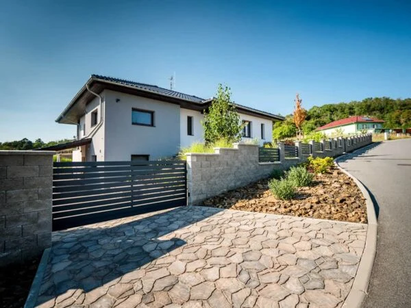 Moderní dům s plotem a dlažbou před domem