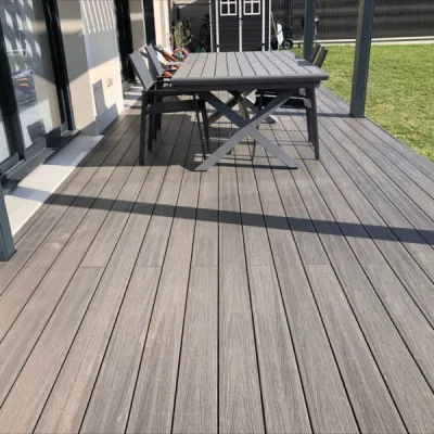 Moderní terasa z kompozitových prken s venkovním jídelním stolem.