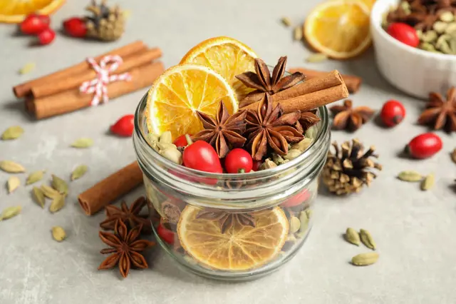 Sklenice s suroviny pro potpourri: pomelo, hřebíček, skořice.
