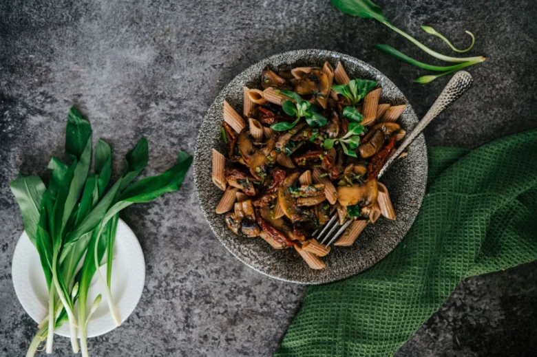 Pasta s žampiony na talíři jako hotový recept.