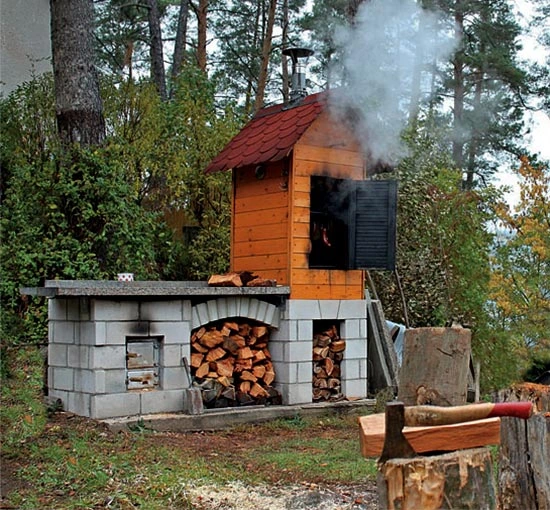 Dřevěná domácí udírna s kamenem na dřevo v lese