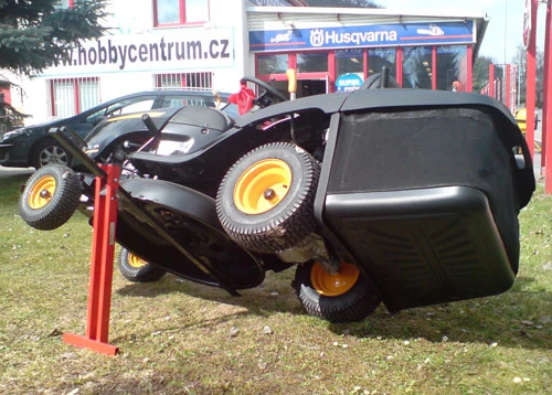 Červený zvedák na zahradní traktor v akci.