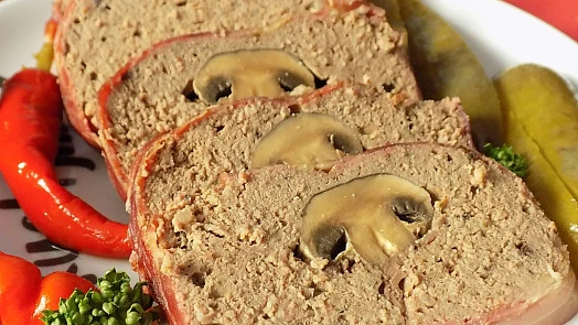 Domácí paštika z pečeného masa s houbami na talíři.