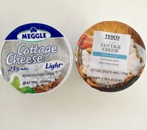 Dva kelímky s cottage сыром od různých výrobců na bílém pozadí.