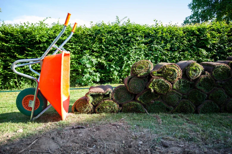 Oranžová vozík vedle baleného trávníku na zahradě.