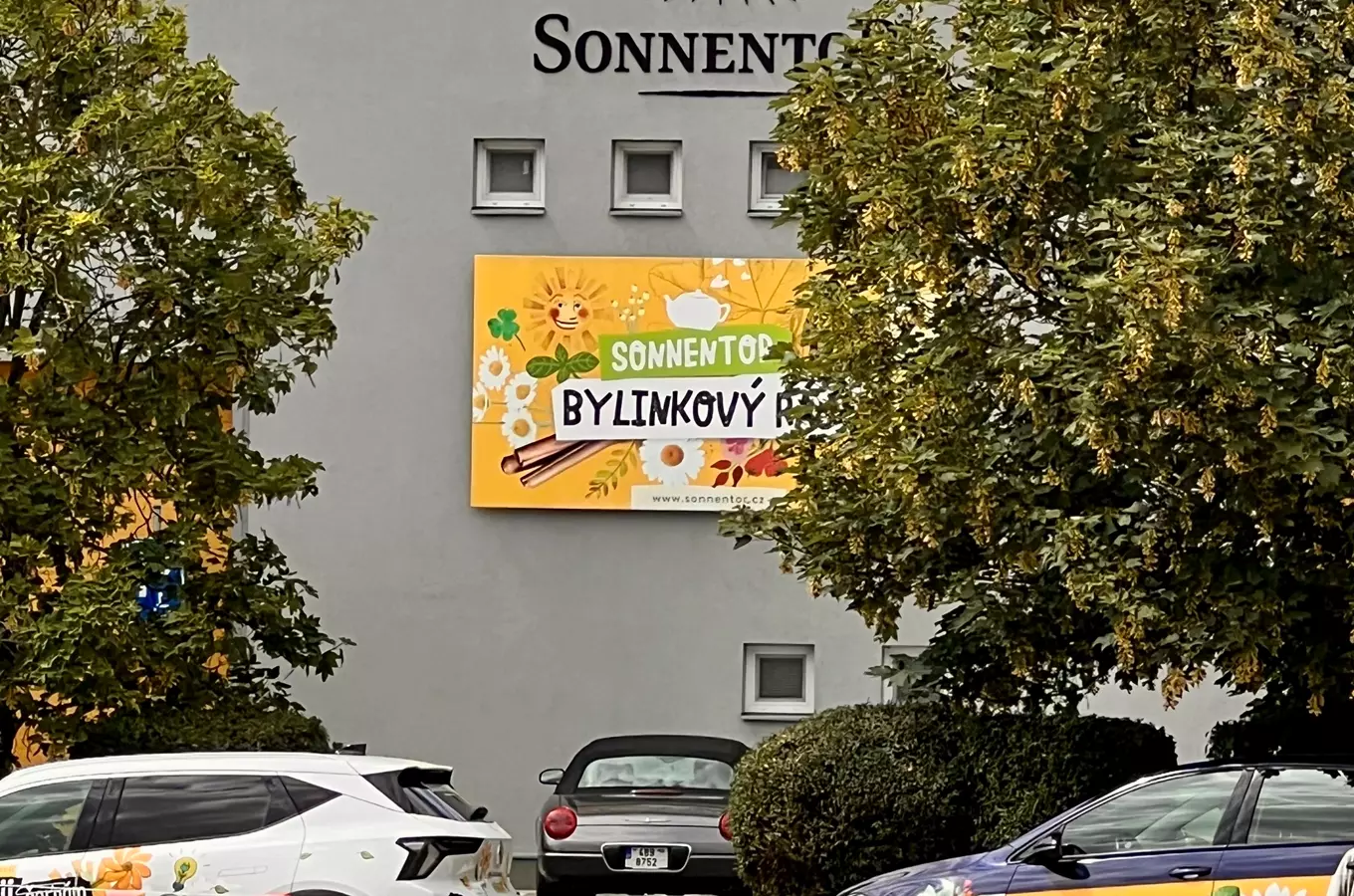 Reklama na bylinky značky Sonnentor u budovy v Čejkovicích.