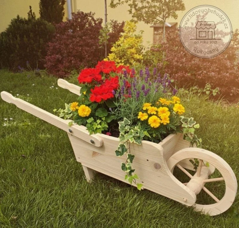 Dřevěný vozík na květiny s barevnými rostlinami v zahradě