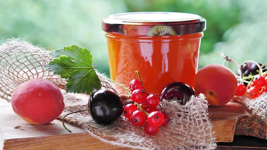 Džem z angreštu s čerstvými ovocnými ingrediencemi na dřevěném podkladu