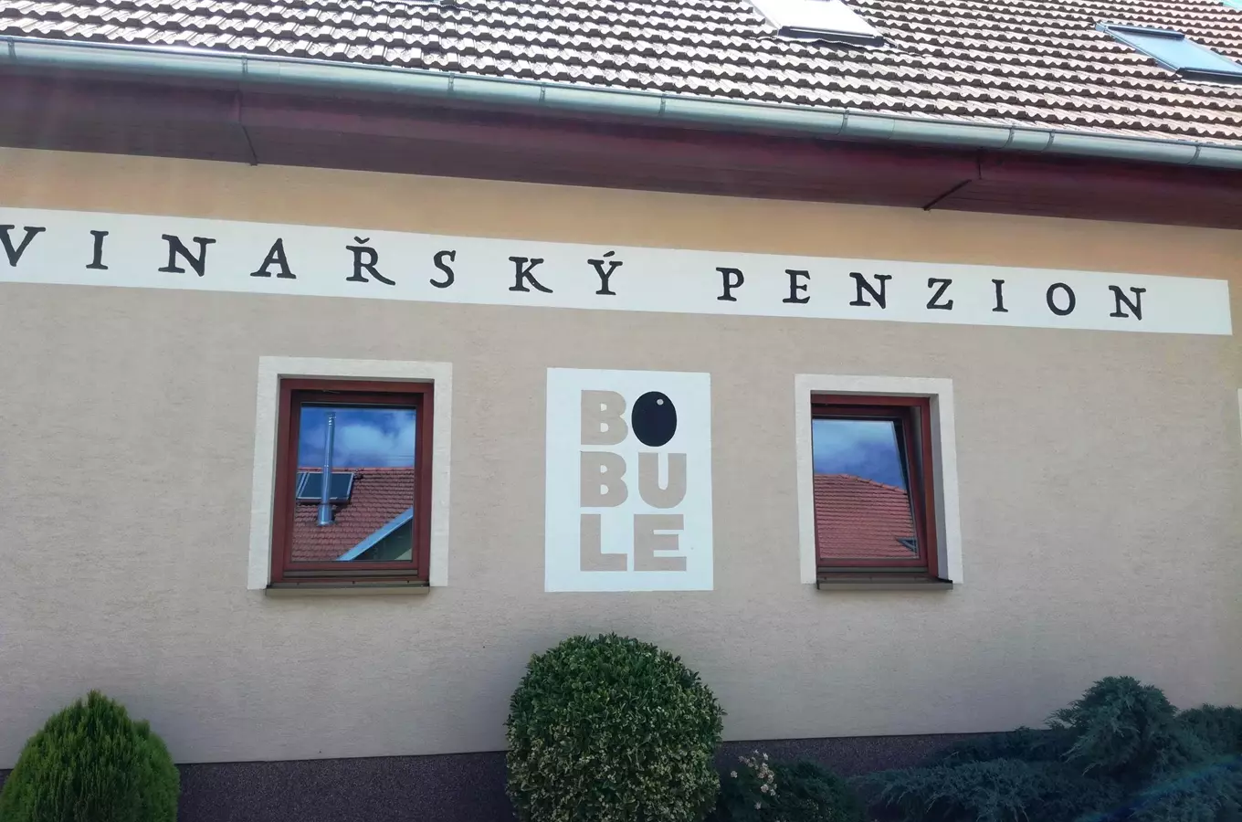 Fasáda vinařského penzionu Bobule s logem mezi okny.
