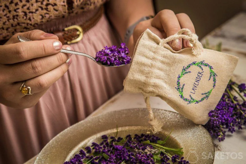 Ručník s levandulí v lžičce vedle pytlíku označeného slovem LAVENDER.